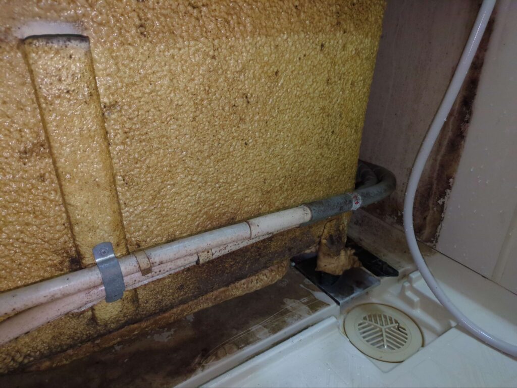 横浜市のエプロン内高圧洗浄前のカビや水垢が目立つエプロン内部