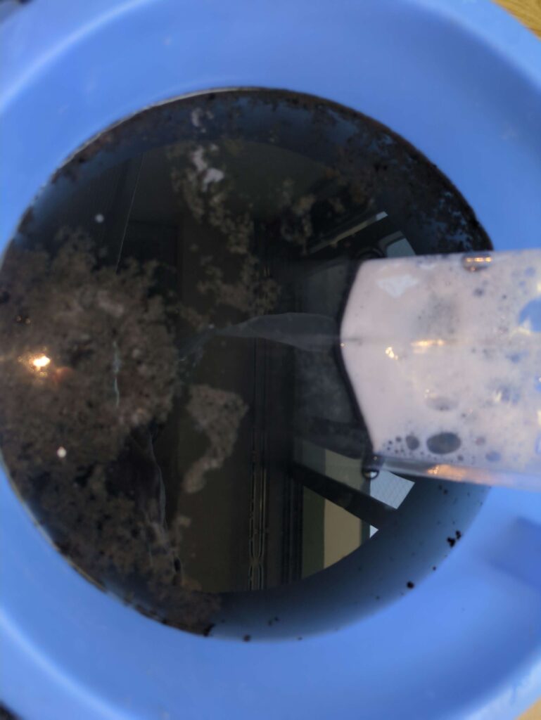 高圧洗浄後の黒カビを含んだ汚水