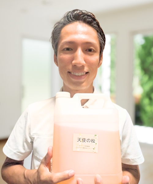 清掃作業の際に中心的に使用する洗剤「天使の松」を抱えているお掃除のキレイエ代表