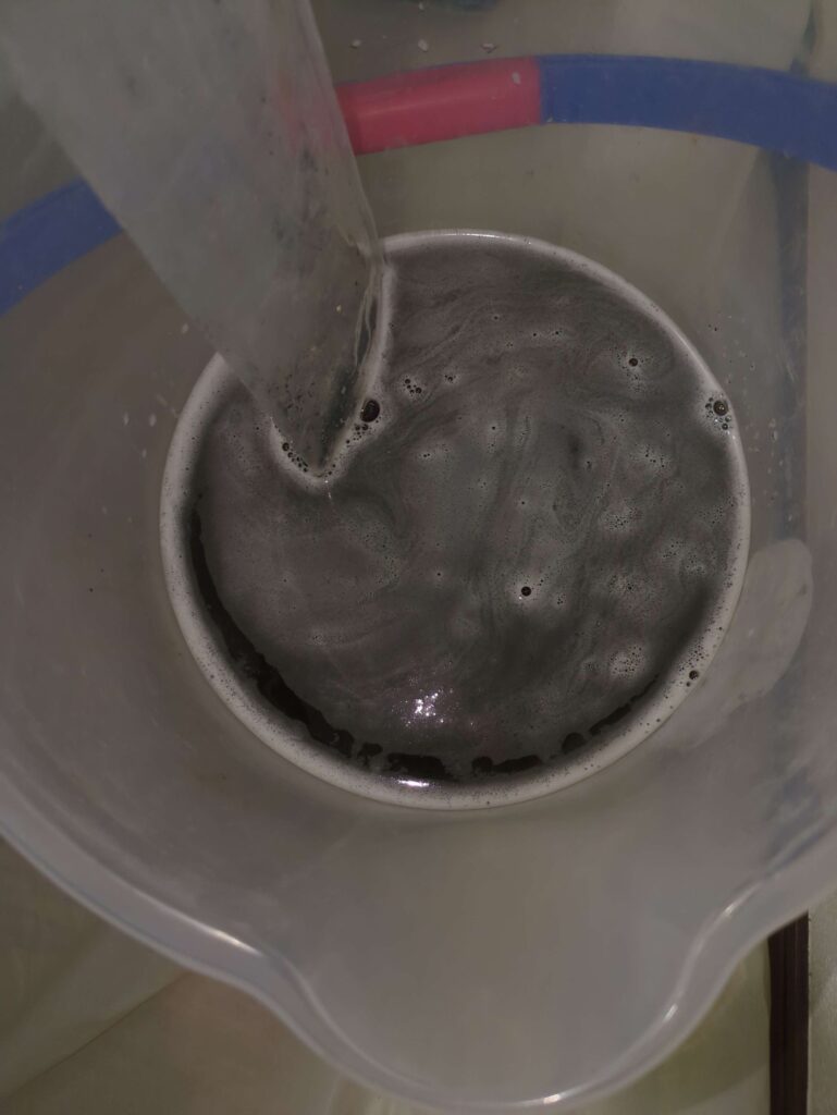 横浜市港南区のダイキン製エアコン。分解洗浄後の黒カビが大量の汚水。