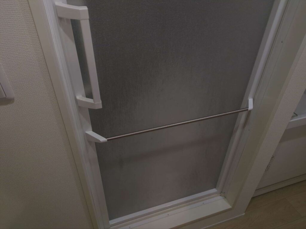 横浜市中区の浴室で、浴室扉が石鹸で白く汚れている様子