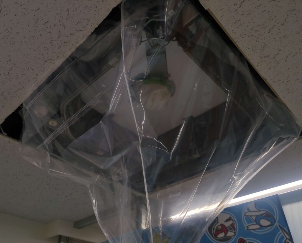 ダイキン製の業務用エアコンの分解洗浄の養生の様子。PC上に業務用エアコンがある。