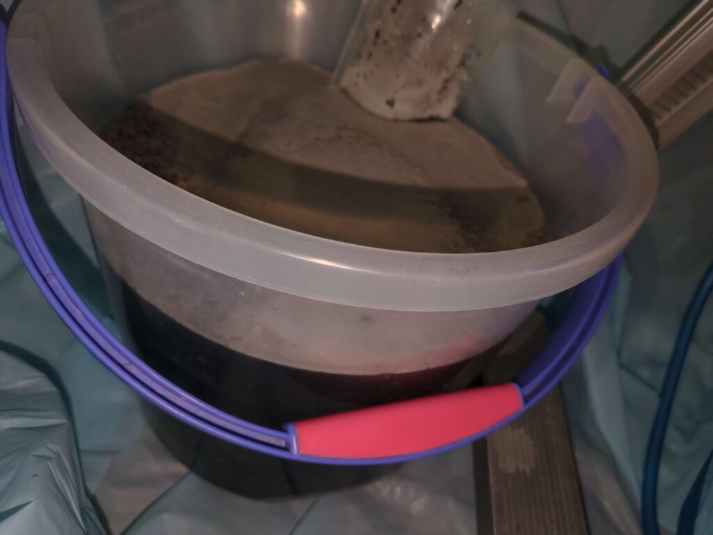 横浜市磯子区で、業務用壁掛けエアコンの分解洗浄後の黒カビで真っ黒になった汚水