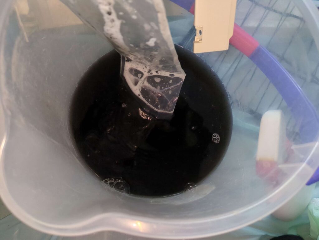横浜市瀬谷区で三菱製エアコンの分解洗浄後の黒カビで真っ黒な汚水