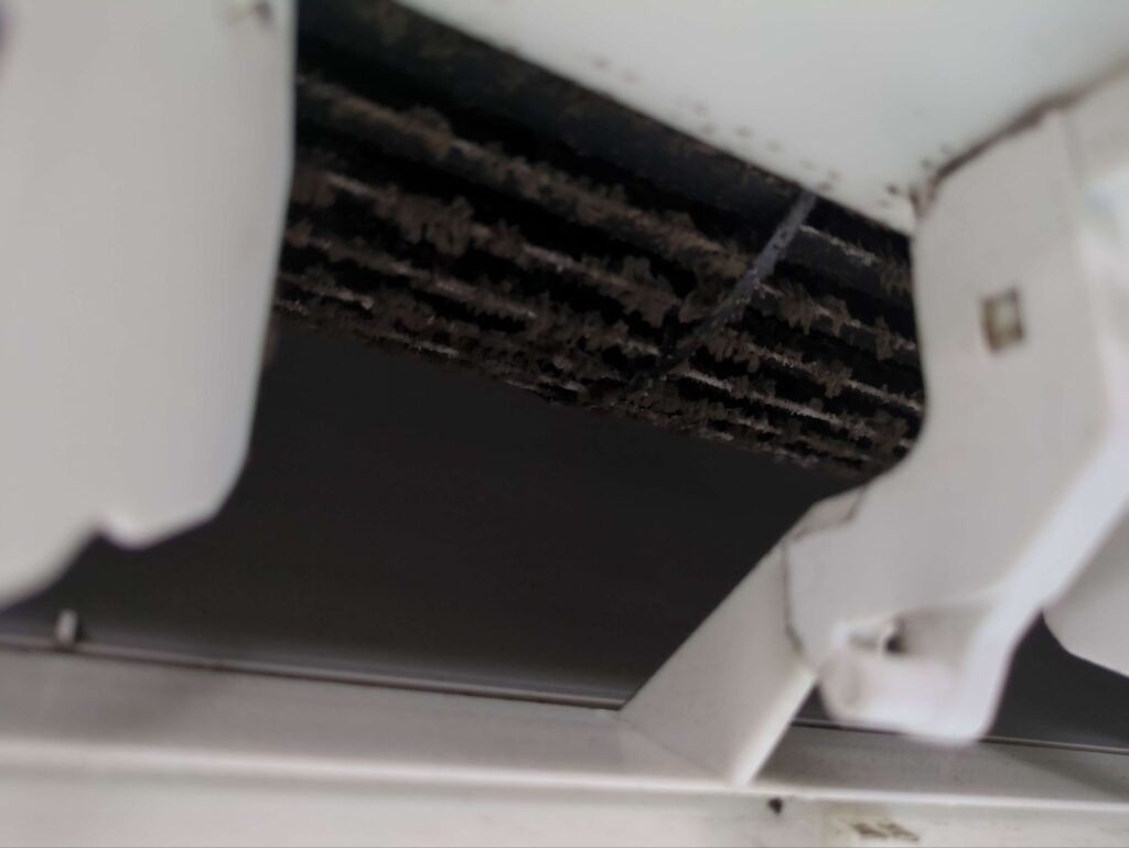 川崎市中原区でリピートにて分解洗浄をご依頼頂いたご家庭のリビングエアコンの作業前の黒カビが堆積した送風ファンの様子