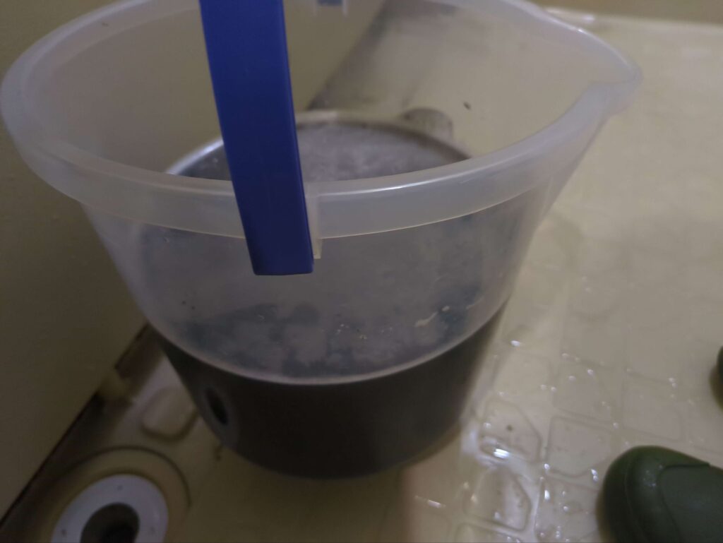 川崎市中原区でリピートにて分解洗浄をご依頼頂いたご家庭のリビングエアコンの作業後の黒カビで真っ黒になった汚水
