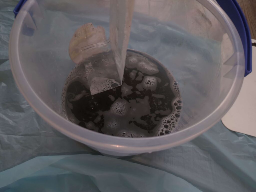 横浜市中区でノーリツ2001年製エアコンの分解洗浄を行ったあとの黒くなっている汚水