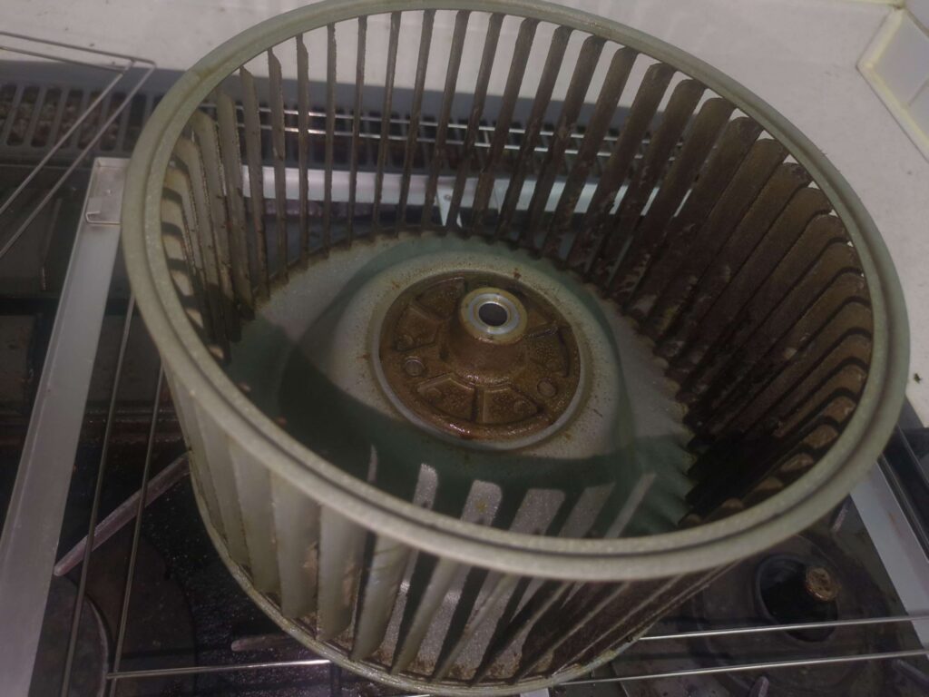 横浜市戸塚区でレンジフード分解洗浄を行う前の油がこびりついたシロッコファンの状態