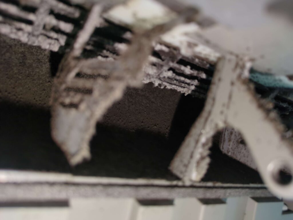 横浜市鶴見区でエアコン分解洗浄前のカビが堆積した送風口の様子