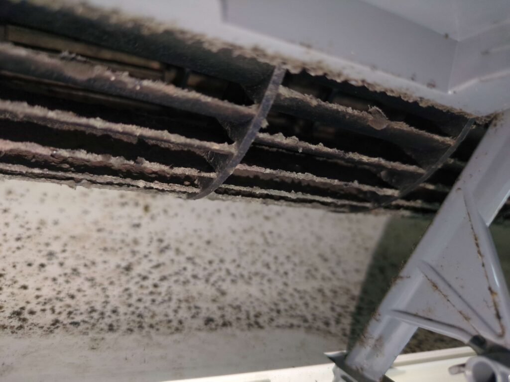 横浜市緑区で三菱電機製お掃除機能付きエアコンの分解洗浄前の黒カビで真っ黒な送風口